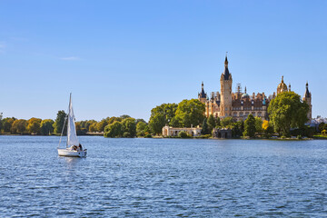 Schöner Blick auf das berühmte Schweriner Schloss, mit Segelboot im Vordergrund, in Deutschland, Mecklenburg-Vorpommern.
