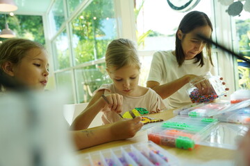 Teacher in workshop teched two girls how to assemble a thermo mosaic 