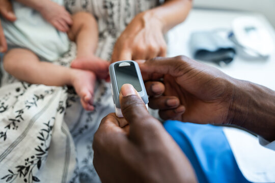 Doctor measuring baby oxygen saturation using pulse oximeter