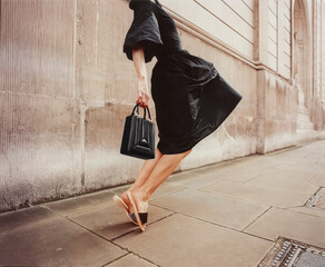 Elegant Woman in Black Dress Walking on City Sidewalk