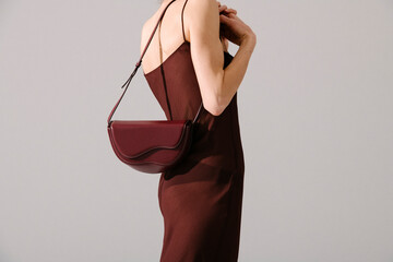 Elegant Woman with Stylish Burgundy Bag in Minimalist Dress