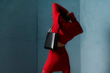 Stylish Woman in Red Outfit Posing with Black Handbag