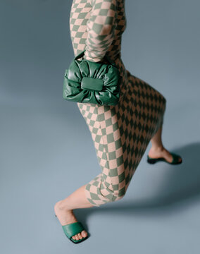 Fashionable Woman in Checkered Dress with Green Handbag