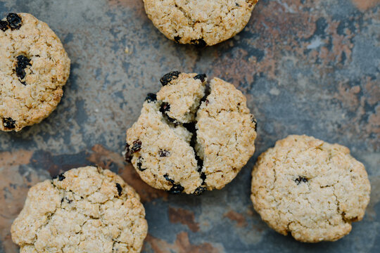 Close-up of broken oat cookie on worn, rustic background