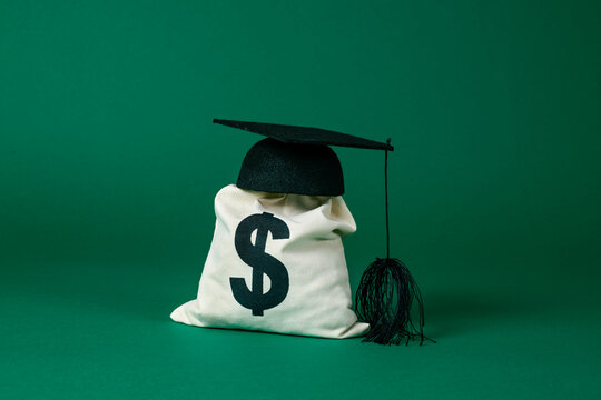graduate cap on top of a money sack