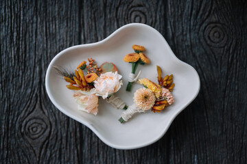 Artful Flower Corsage in White Ceramic Dish on Table