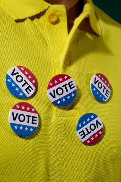 man wears a lot of vote badges on his shirt