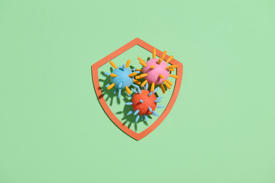 Colorful Virus Cells Protected by Shield on Blue Background