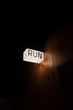 A glowing "RUN" sign illuminated in a dark, dimly lit room