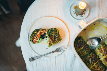 Sliced stuffed cabbage roll on table with candle.