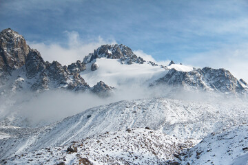 Mountains and rocks with a glacier in the snow, clear day