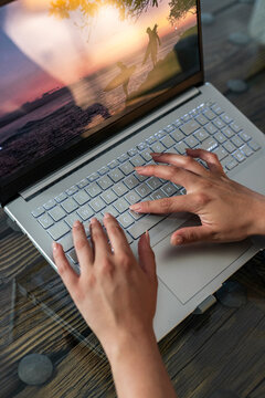 Digital nomad hands typing on laptop keyboard