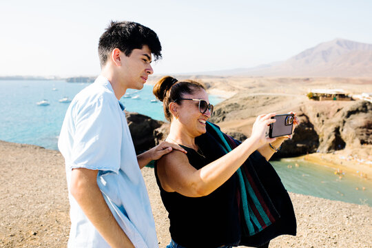 Mother and son use a mobile to photograph the landscape of Lanzarote