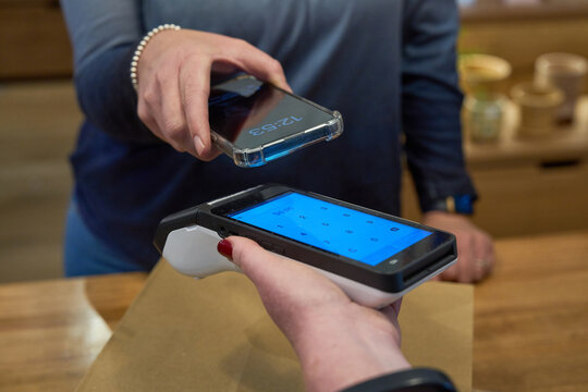 Customer making a contactless payment using a smartphone at a store