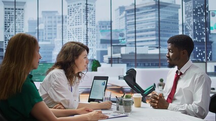 HR recruiters team interviewing a candidate with crutches in office, asking him about qualifications and business administration studies. Employment staff talk with a job applicant. Camera B.