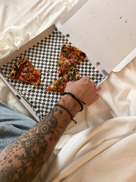 Tattooed Arm Grabs Pizza Slice