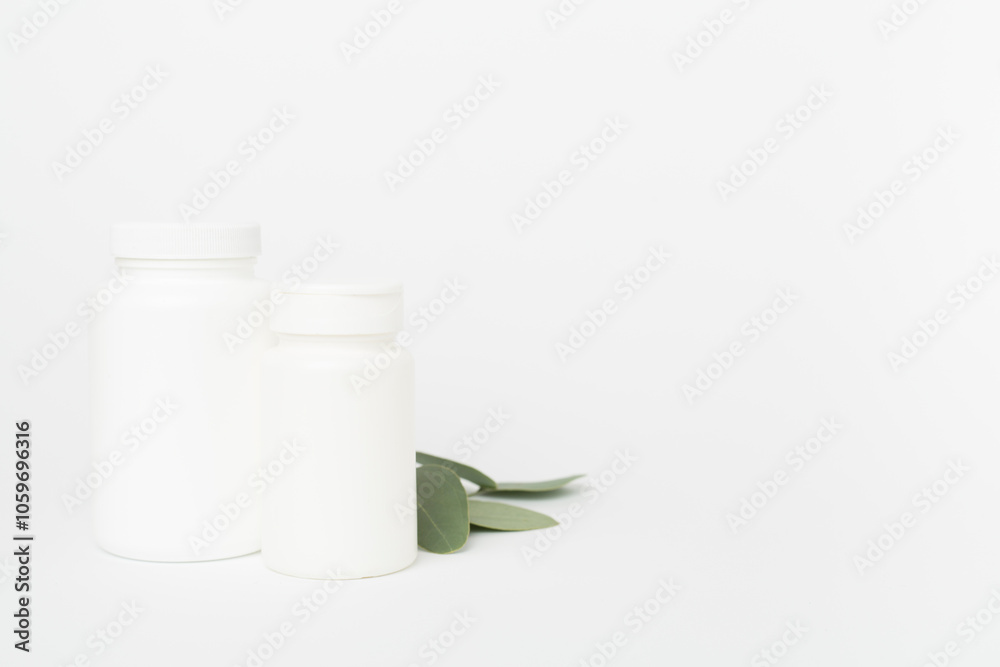 Sticker Bottles with pills and green leaves on color background