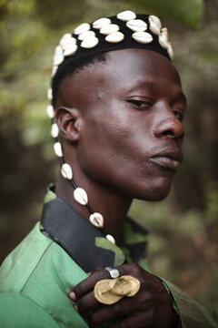 a model in a causal outfit wearing a hat filled with cowries shells