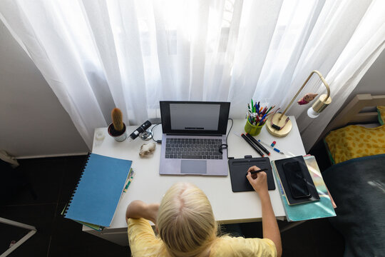 Schoolgirl prepares for exams while sitting at a computer - Powered by Adobe