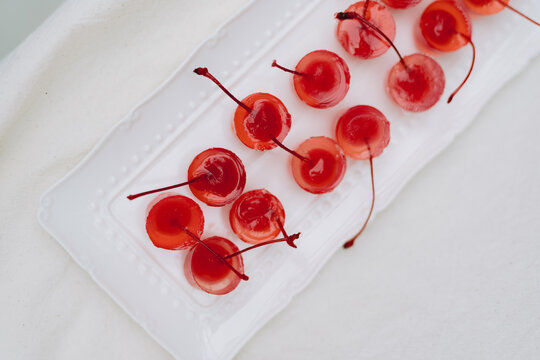 Red maraschino cherries on white plate with white cloth
