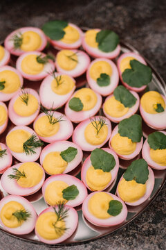 Plate of perfectly prepared deviled eggs in pink shells