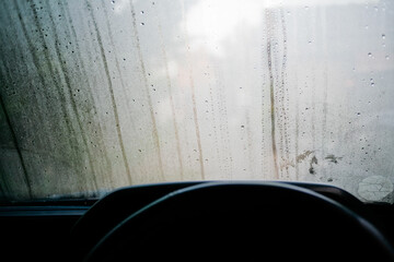 close-up view of sweaty car with dew all over windshield