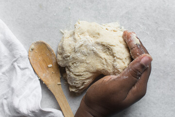 Overhead view of challah dough being kneaded on a white countertop, top view of homemade challah...