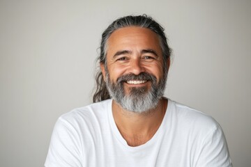Obraz premium Portrait of a Happy Man Smiling with Long Hair and Beard in White T-Shirt on Neutral Background