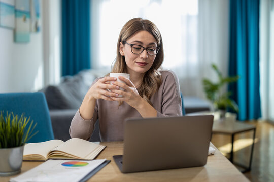 Young Woman Working Remotely From Home With Laptop and Coffee