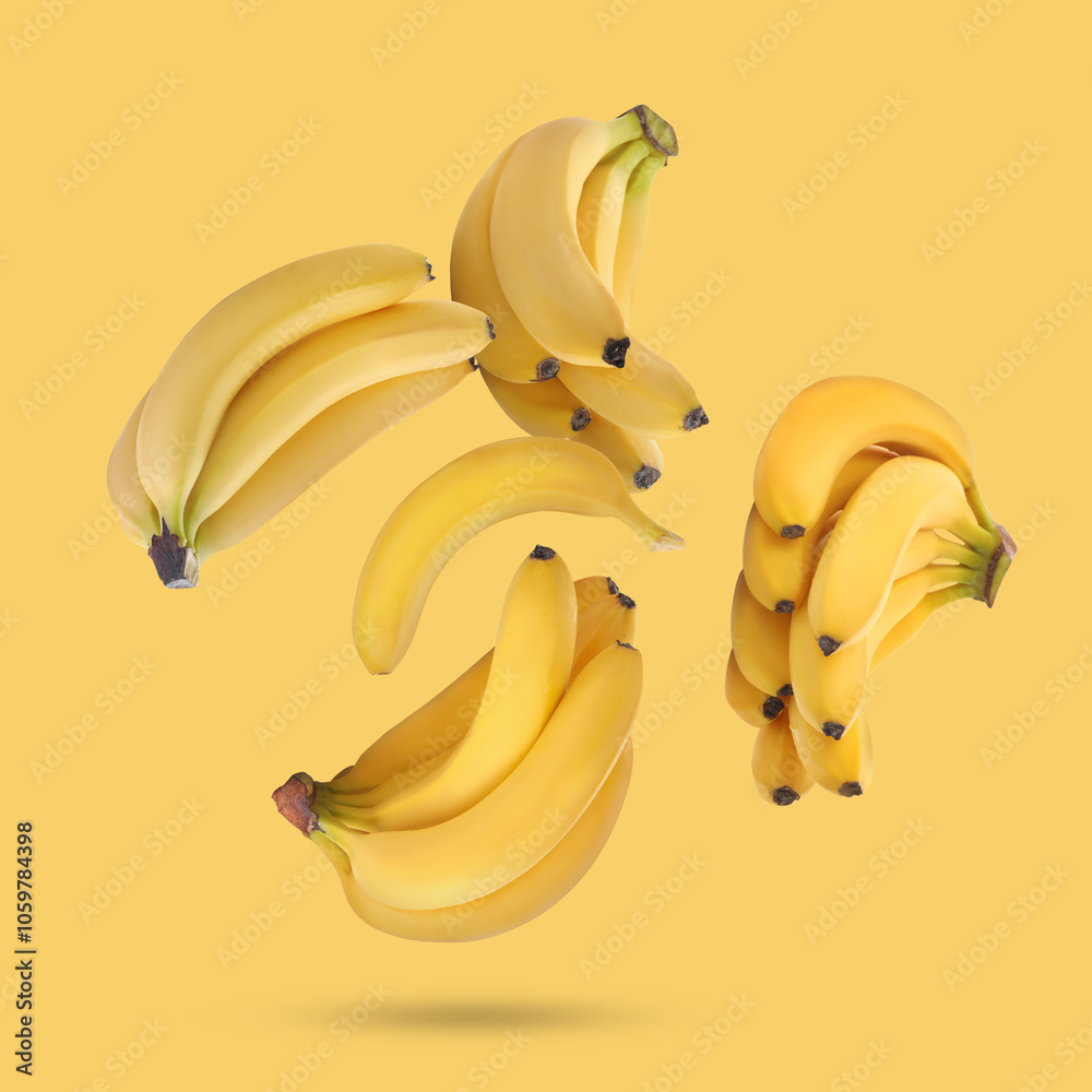 Wall mural many fresh bananas falling on yellow background