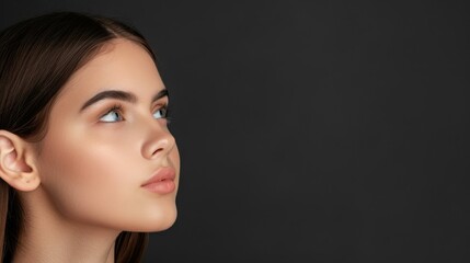 Fototapeta premium Stunning closeup of a young womans flawless skin, highlighting her natural beauty against a dramatic black backdrop.
