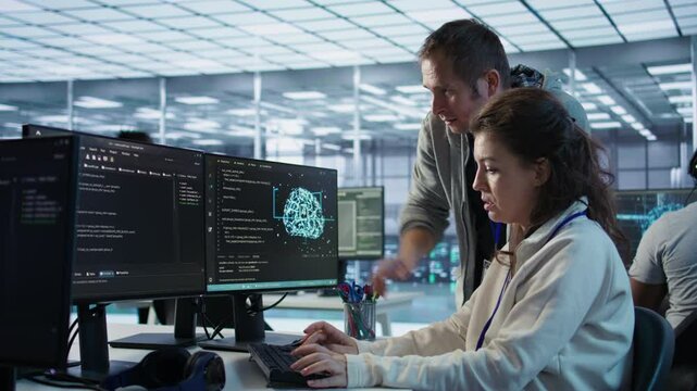IT team members programming scripts on computer, employing AI machine learning. Software developer and coworker manipulating lines of code for artificial intelligence applications, camera B