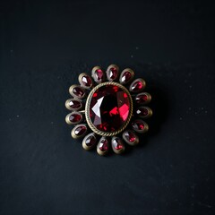 Vintage style garnet brooch in antique brass on plain black dark background