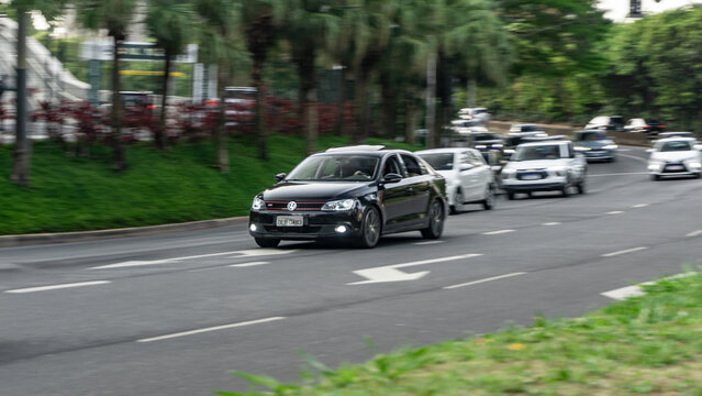 Black Volkswagen Jetta in city traffic, high end sedan in movement, High Resolution panning shot