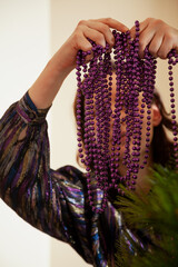 Hands hang garland on Christmas tree close up..