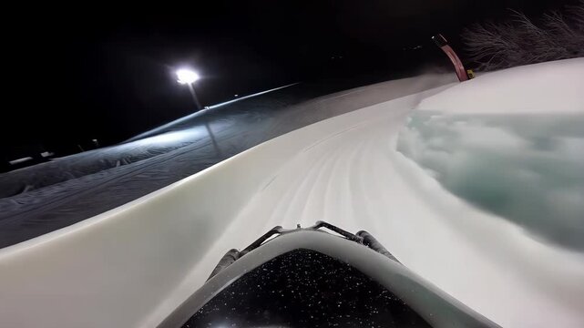 POV shot of a bobsled racing down an icy, winding track at high speed