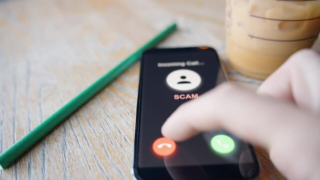 A hand reaching to decline an incoming scam call on a smartphone screen, highlighting a proactive response to phone scams and digital security awareness.