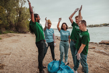 Volunteers picking up waste on the beach celebrating © bernardbodo