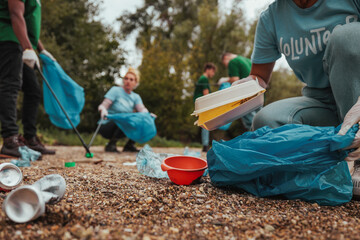Volunteers collecting trash in park: environmental cleanup activity