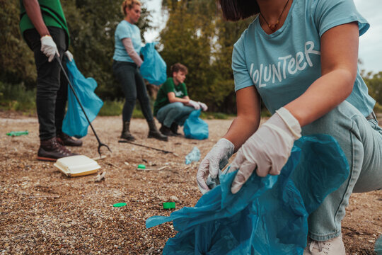 Volunteers picking up trash in polluted park