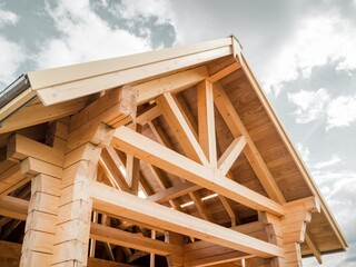 a detailed view of the roof structure of a wooden house under construction. 