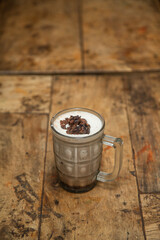 Ice cream juice with chocolate Chips, Glass bowl full of vanilla ice cream with chocolate chips placed in a wooden plywood or Wooden Dining table