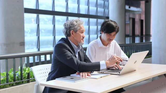 Asian senior professor is giving advice to the college student on the research thesis while sitting in the university faculty for education, academic and business