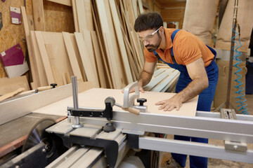 Craftsman cutting woods on pieces working at circular cutting table