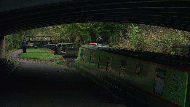 STOKE-ON-TRENT, STAFFORDSHIRE, ENGLAND - OCTOBER 30 2024: Man and woman opening a lock on the Caldon canal whilst a child drives the narrowboat sequence 3 of 3.