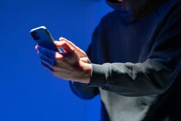 スマホを操作する覆面ハッカー