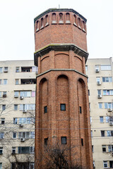Old historical water tower made of red bricks in Drumul Taberei neighborhood in Bucharest, Romania, in a cloudy winter day