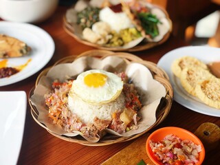Balinese cuisine, the famous Nasi Campur. Contains fried pork belly. sunny side egg, white rice, and sambal matah. North Jakarta, Indonesia - December 5, 2018.