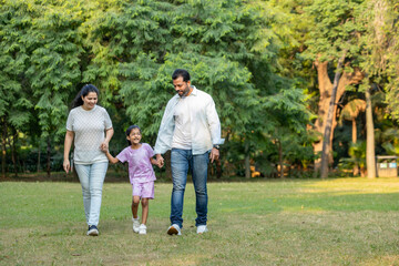 Happy Indian parents walking with Daughter in morning walk
