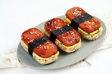 Classic Hawaiian spam musubi, made with grilled spam, seasoned rice, and wrapped with nori seaweed. A delightful fusion snack that combines savory, salty, and umami flavors in each bite.